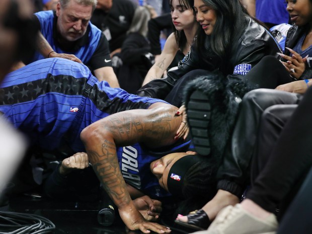 Orlando forward Paolo Banchero falls into the courtside fans during...