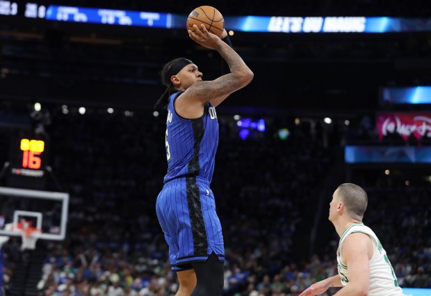Orlando forward Paolo Banchero (top) shoots a three point shot...