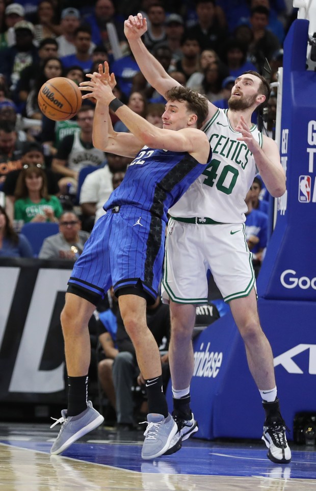 Orlando forward Franz Wagner (22) and Boston center Luke Kornet...