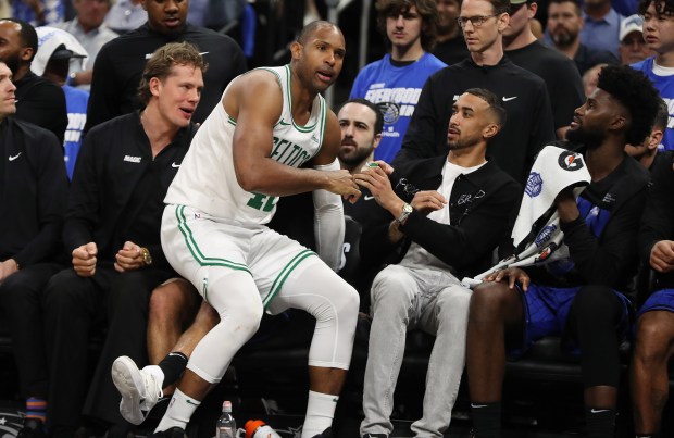 Boston forward Al Horford (42) falls into the Orlando bench...