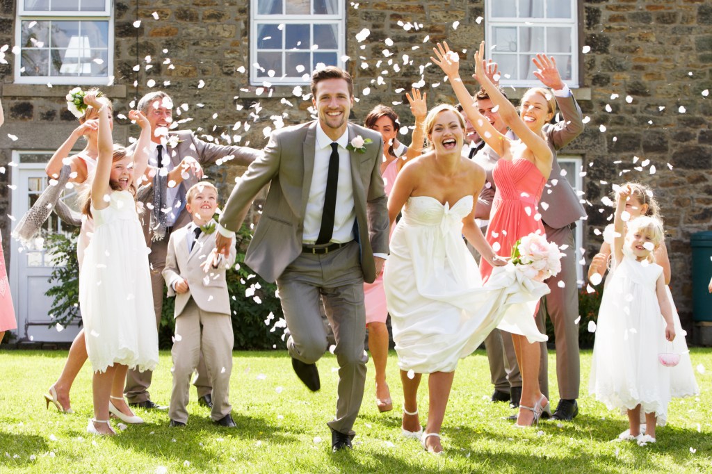 Guests throwing confetti over a smiling bride and groom