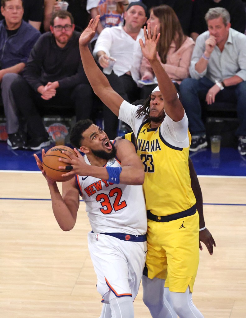 New York Knicks center Karl-Anthony Towns #32, driving to the basket guarded by Indiana Pacers center Myles Turner #33, in the 4th quarter.