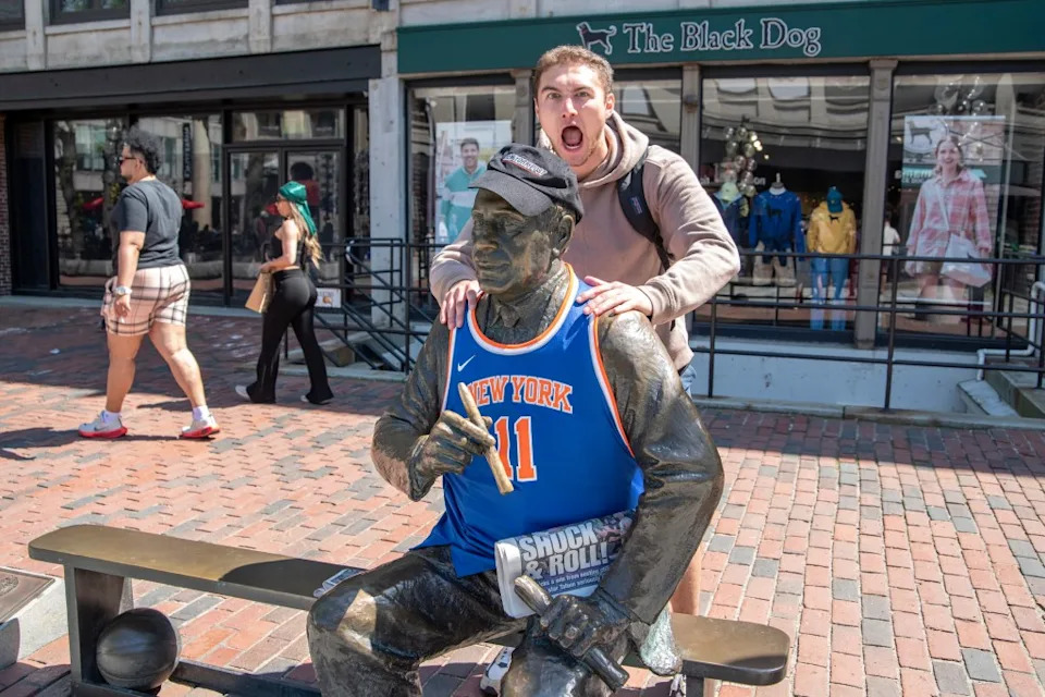 An excited fan stands with the statue in Boston. David McGlynn