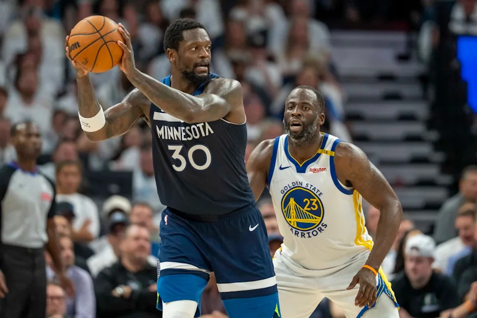 Minnesota Timberwolves forward Julius Randle (30) holds the ball as Golden State Warriors forward Draymond Green (23) plays defense in the second half during game five of the second round for the 2025 NBA Playoffs at Target Center. Mandatory Credit: Jesse Johnson-Imagn Images