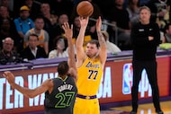 Los Angeles Lakers guard Luka Doncic, right shoots as Minnesota Timberwolves center Rudy...