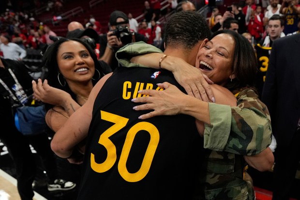 Golden State Warriors' Stephen Curry (30) hugs his mother, Sonya, as he wife, Ayesha, left, looks on after Game 7 of an NBA basketball first-round playoff series against the Houston Rockets Sunday, May 4, 2025, in Houston. (AP Photo/Ashley Landis)