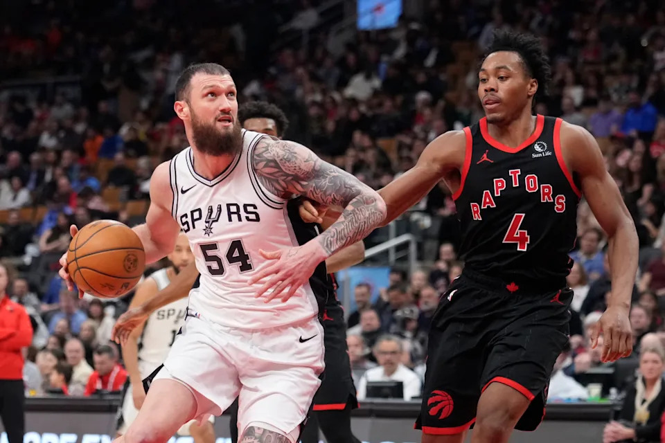 San Antonio Spurs forward Sandro Mamukelashvili (54) drives to the net against Toronto Raptors guard Scottie Barnes (4).© John E. Sokolowski-Imagn Images