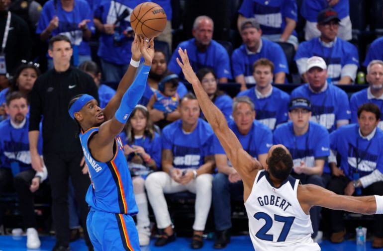 Oklahoma City Thunder guard Shai Gilgeous-Alexander shoots against Minnesota Timberwolves center Rudy Gobert