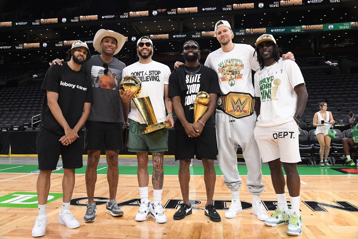 BOSTON, MA - JUNE 21: Derrick White #9, Al Horford #42, Jayson Tatum #0, Jaylen Brown #7, Kristaps Porzingis #8, and Jrue Holiday #4 of the Boston Celtics pose for a photograph with the Larry O’Brien Trophy and the Bill Russell Finals MVP Trophy before the 2024 Boston Celtics championship parade.