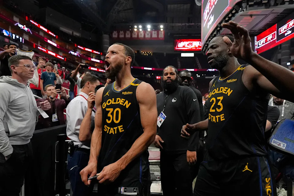 Golden State Warriors' Stephen Curry (30) and Draymond Green (23) celebrate after Game 7 of an NBA basketball first-round playoff series against the Houston Rockets Sunday, May 4, 2025, in Houston. (AP Photo/Ashley Landis)