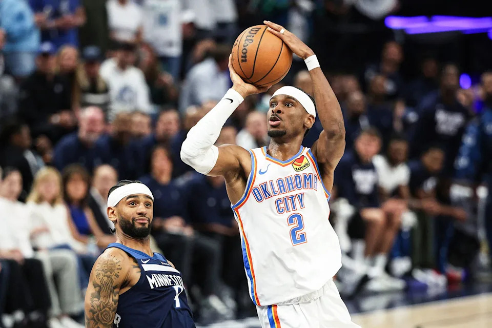 Shai Gilgeous-Alexander jumps to shoot a basket as Nickeil Alexander-Walker watches on (Matt Krohn / AP)