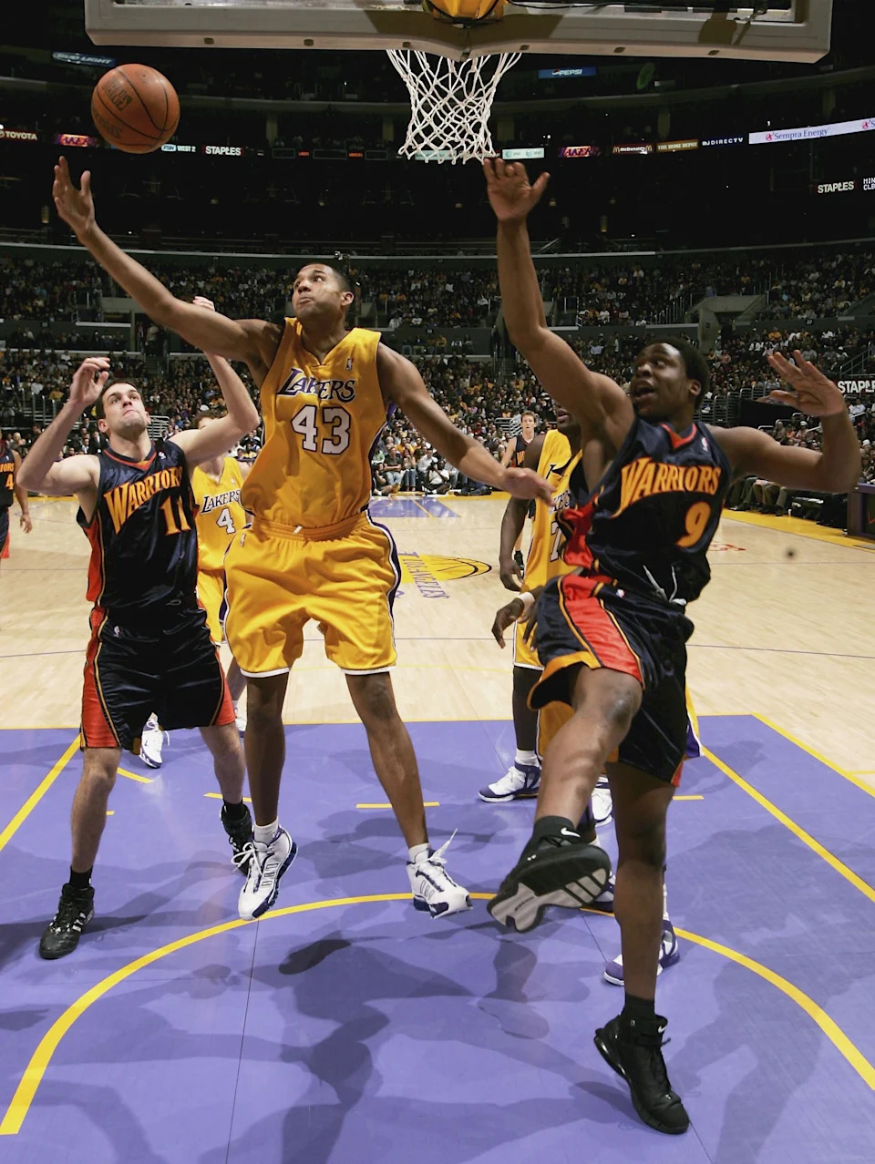 LOS ANGELES - JANUARY 27: Brian Cook #43 of the Los Angeles Lakers grabs a rebound between Zarko Cabarkapa #11 and Ike Diogu #8 of the Golden State Warriors on January 27, 2006 at Staples Center in Los Angeles, California. The Lakers won 106-105 in overtime. NOTE TO USER: User expressly acknowledges and agrees that, by downloading and or using this photograph, User is consenting to the terms and conditions of the Getty Images License Agreement. (Photo by Stephen Dunn /Getty Images)