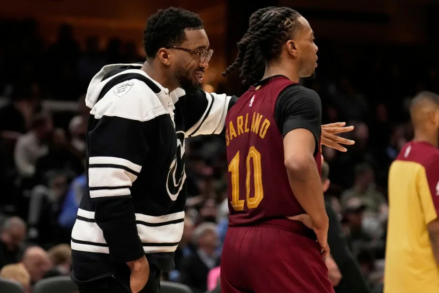Cleveland Cavaliers guard Donovan Mitchell, left, who did not dress for the game, talks with teammate Darius Garland (10) in the second half of an NBA basketball game against the Brooklyn Nets, Tuesday, March 11, 2025, in Cleveland. (AP Photo/Sue Ogrocki)