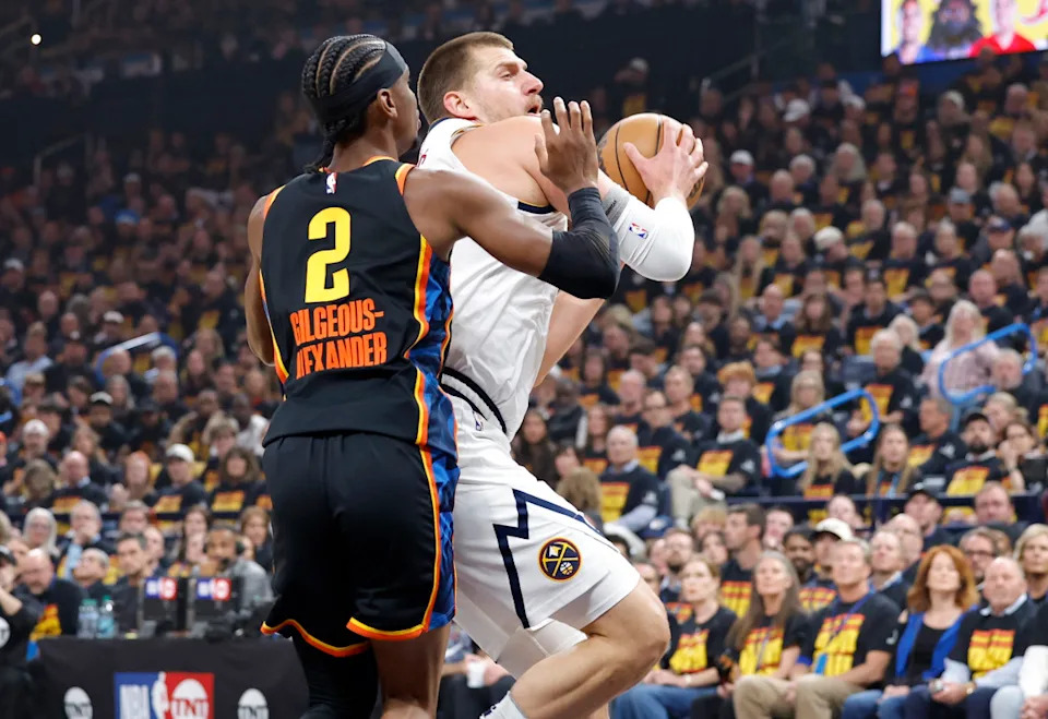 Denver Nuggets center Nikola Jokic (15) drives against Oklahoma City Thunder guard Shai Gilgeous-Alexander (2) during the first quarter in game one of the second round for the 2025 NBA Playoffs at Paycom Center. Mandatory Credit: Alonzo Adams-Imagn Images