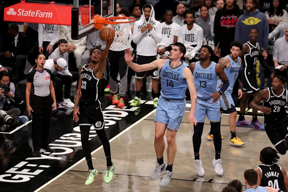 Brooklyn Nets center Nic Claxton (33) drives to the basket against Memphis Grizzlies center Zach Edey (14).Brad Penner-Imagn Images