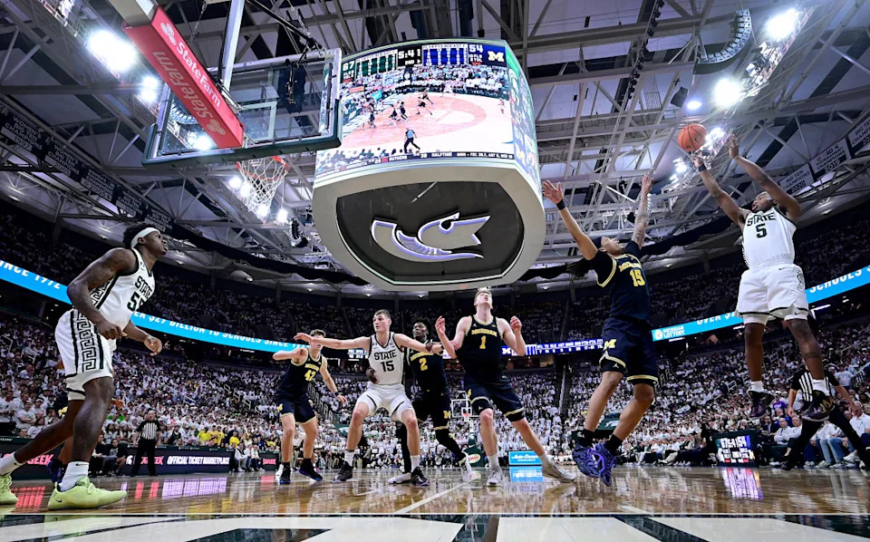 Tre Holloman (No. 5 right) fires a shot during Michigan State's game against Michigan at the Breslin Center© Dale Young-Imagn Images