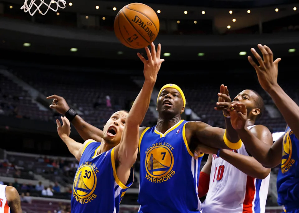 Feb 24, 2014; Auburn Hills, MI, USA; Golden State Warriors point guard Stephen Curry (30) grabs the rebound over Golden State Warriors center Jermaine O'Neal (7) and power forward David Lee (10) in the fourth quarter at The Palace of Auburn Hills. © Rick Osentoski-Imagn Images
