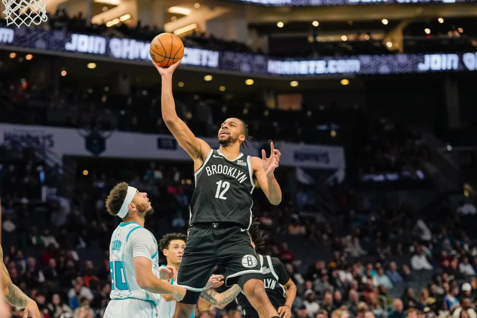 Jan 29, 2025; Charlotte, North Carolina, USA; Brooklyn Nets forward Tosan Evbuomwan (12) with a layup against Charlotte Hornets guard Seth Curry (30) during the second quarter at Spectrum Center. Mandatory Credit: Jim Dedmon-Imagn Images