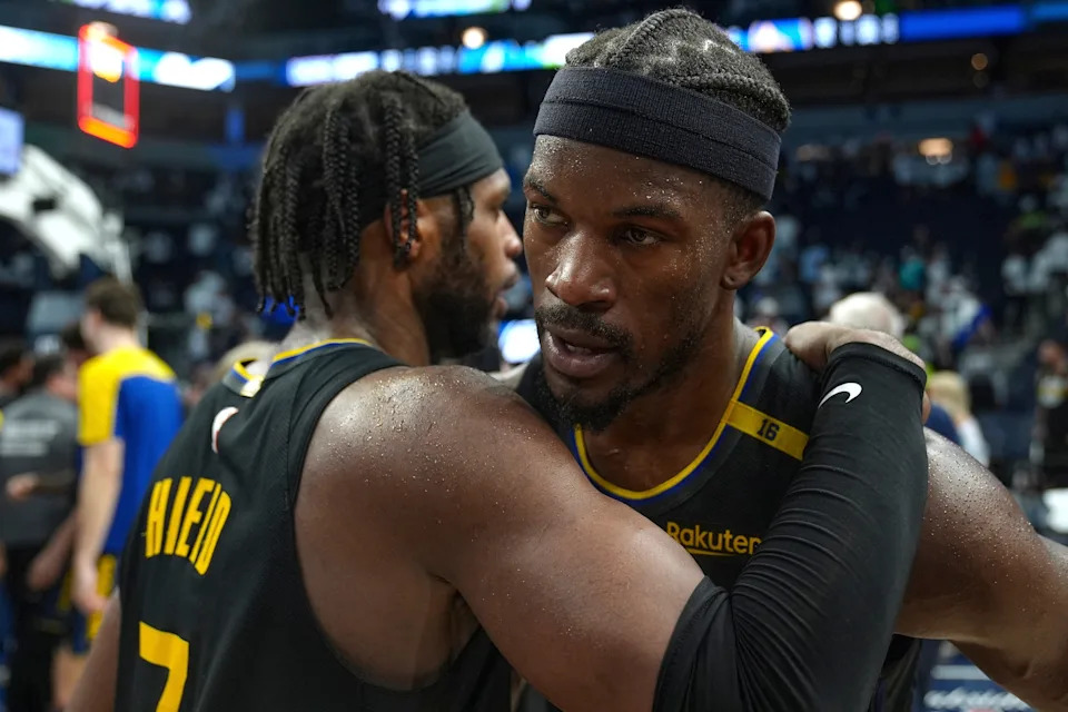 Golden State Warriors guard Buddy Hield (7), left, and forward Jimmy Butler (10) hug after Game 1 of an NBA basketball second-round playoff series against the Minnesota Timberwolves, Tuesday, May 6, 2025, in Minneapolis. (AP Photo/Abbie Parr)