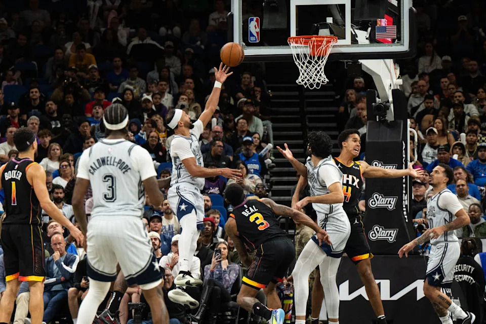 Orlando Magic guard Jalen Suggs lays the ball over Phoenix Suns forward Iso Ighodaro in the fourth quarter at Kia Center.Mandatory Credit&colon; Jeremy Reper-Imagn Images