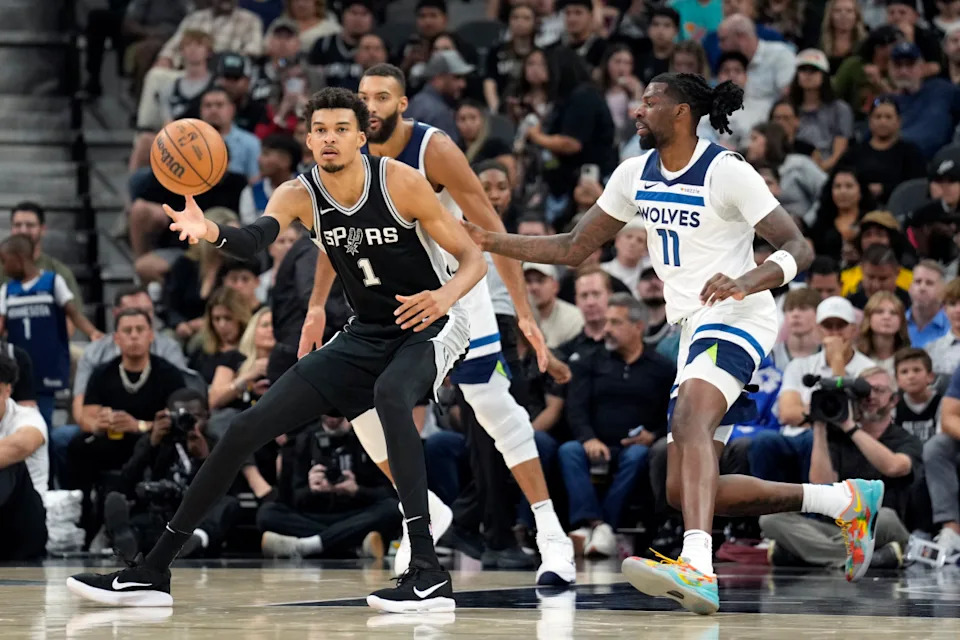 San Antonio Spurs center Victor Wembanyama (1) passes the ball while defended by Minnesota Timberwolves center Naz Reid (11)© Scott Wachter-Imagn Images