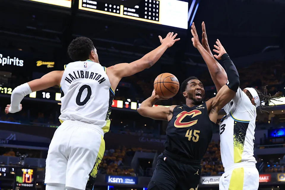 Cleveland Cavaliers guard Donovan Mitchell (45) goes up for a shot between Indiana Pacers defenders Tyrese Haliburton (0) and Myles Turner during Game 3 of a second-round playoff series May 9, 2025, in Indianapolis, Indiana.