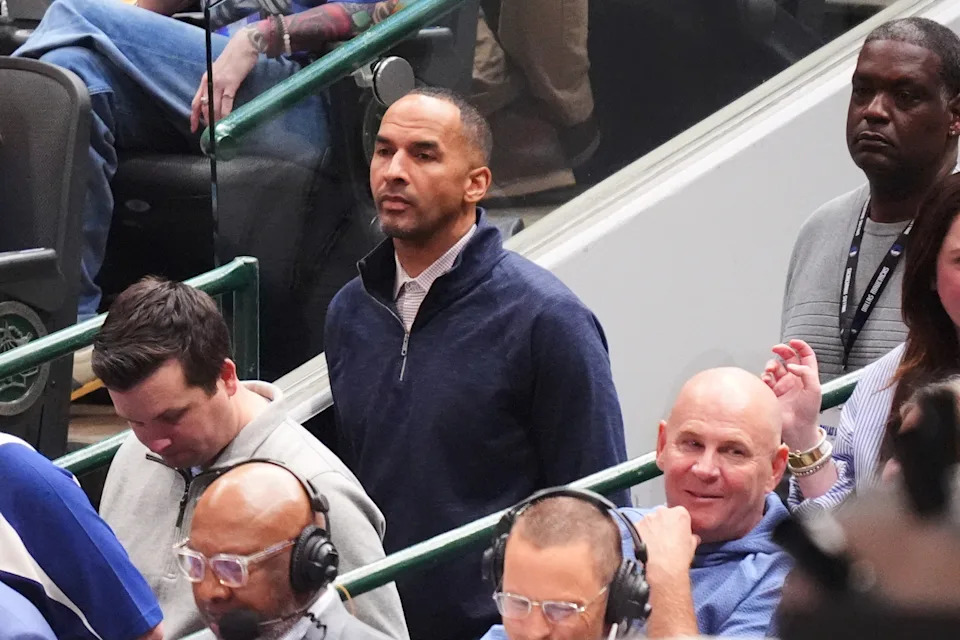 Nico Harrison, center rear, the Dallas Mavericks general manager watches the team play against the Toronto Raptors in the second half of an NBA basketball game in Dallas, Friday, April 11, 2025. (AP Photo/LM Otero)