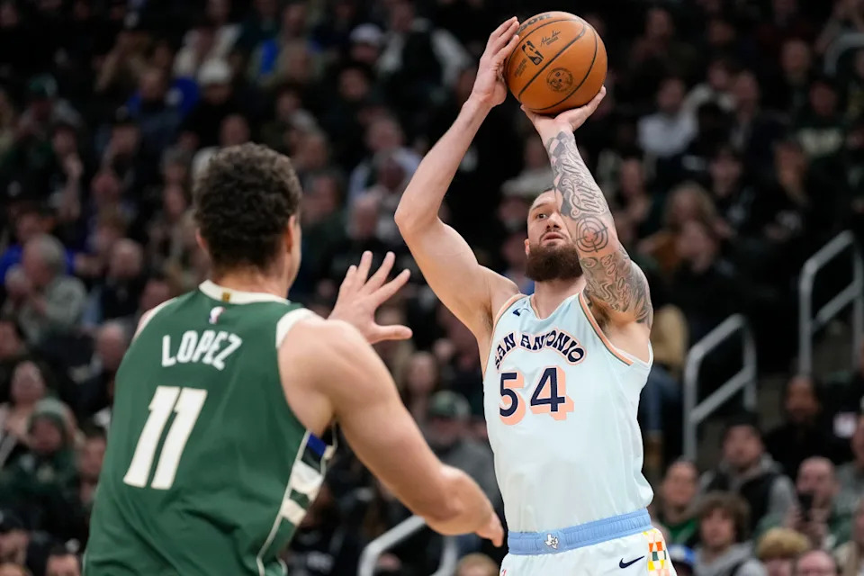 Jan 8, 2025; Milwaukee, Wisconsin, USA; San Antonio Spurs forward Sandro Mamukelashvili (54) shoots over Milwaukee Bucks center Brook Lopez (11) during the second quarter at Fiserv Forum. © Jeff Hanisch-Imagn Images