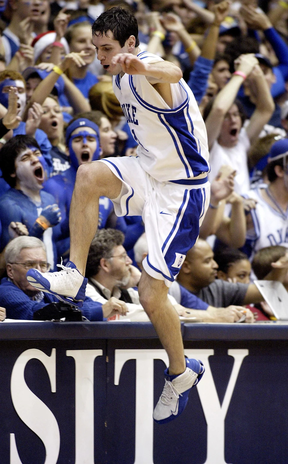 J.J. Redick #4 of the Duke Blue Devils jumps into the stands to save a loose ball.