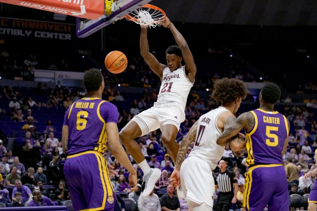 Texas A&M forward Pharrel Payne (21) dunks next to LSU forward Robert Miller III (6) and guard Cam Carter (5) during the second half of an NCAA college basketball game in Baton Rouge, La., Saturday, March 8, 2025. (AP Photo/Matthew Hinton)