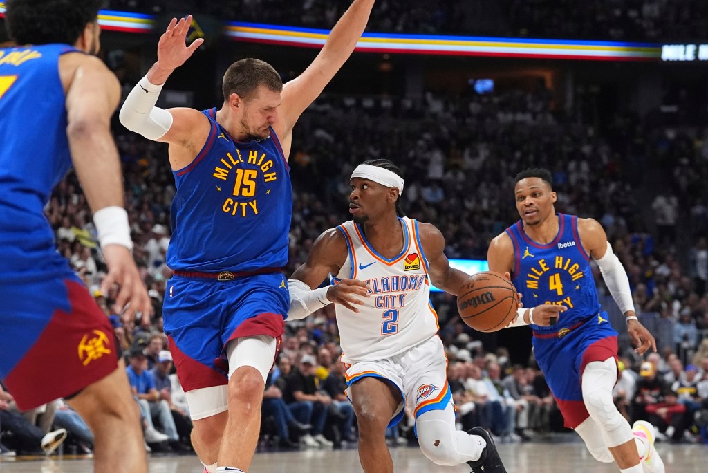 Oklahoma City Thunder guard Shai Gilgeous-Alexander, center, drives to the basket as Denver Nuggets center Nikola Jokic, left, and guard Russell Westbrook defend in the second half of Game 3 in the Western Conference semifinals of the NBA basketball playoffs Friday, May 9, 2025, in Denver.