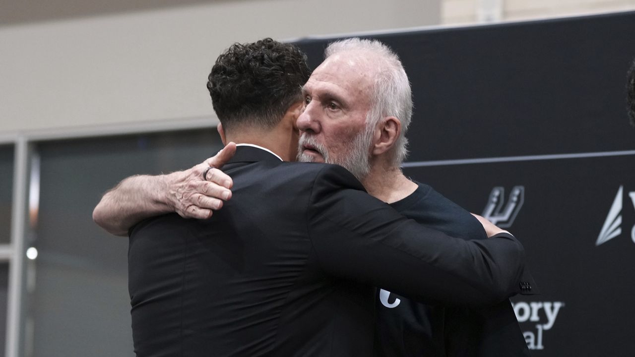 Former San Antonio Spurs head coach Gregg Popovich, right, hugs Mitch Johnson, left, the new head coach of the San Antonio Spurs NBA basketball team, in San Antonio, Monday, May 5, 2025. (AP Photo/Eric Gay)