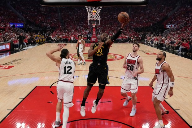 Golden State Warriors' Jonathan Kuminga (00) shoots as Houston Rockets' Steven Adams (12), Alperen Sengun (28) and Dillon Brooks (9) defend during the first half of Game 7 of an NBA basketball first-round playoff series Sunday, May 4, 2025, in Houston. (AP Photo/Ashley Landis)