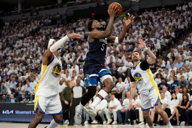 Minnesota Timberwolves guard Anthony Edwards (5) looks to shoot against Golden State Warriors' Pat Spencer, right, and Buddy Hield, left, during the second half of Game 5 of an NBA basketball second-round playoff series, Wednesday, May 14, 2025, in Minneapolis. (AP Photo/Abbie Parr)
