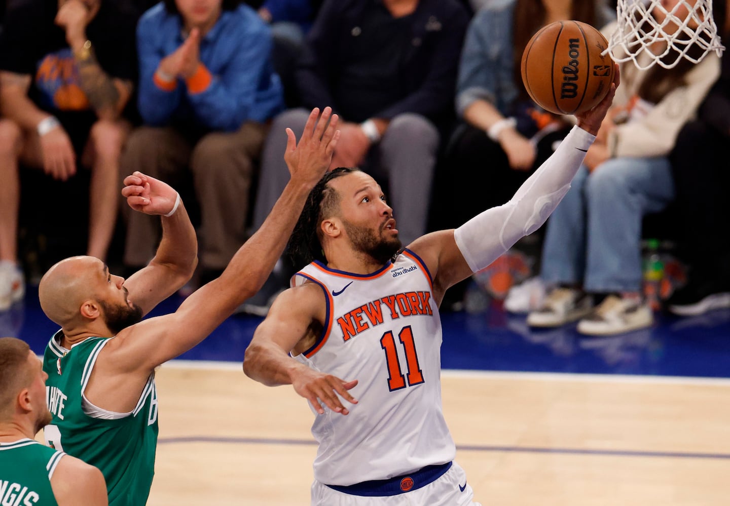 New York Knicks guard Jalen Brunson (11) drives to the basket past Boston Celtics guard Derrick White (9) during the second quarter.
