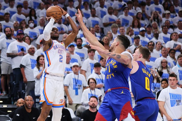 Oklahoma City Thunder's Shai Gilgeous-Alexander (2) shoots over Denver Nuggets' Michael Porter Jr. (1) and Christian Braun (0) in the second half of Game 5 of an NBA basketball second-round playoff series Tuesday, May 13, 2025, in Oklahoma City. (AP Photo/Nate Billings)