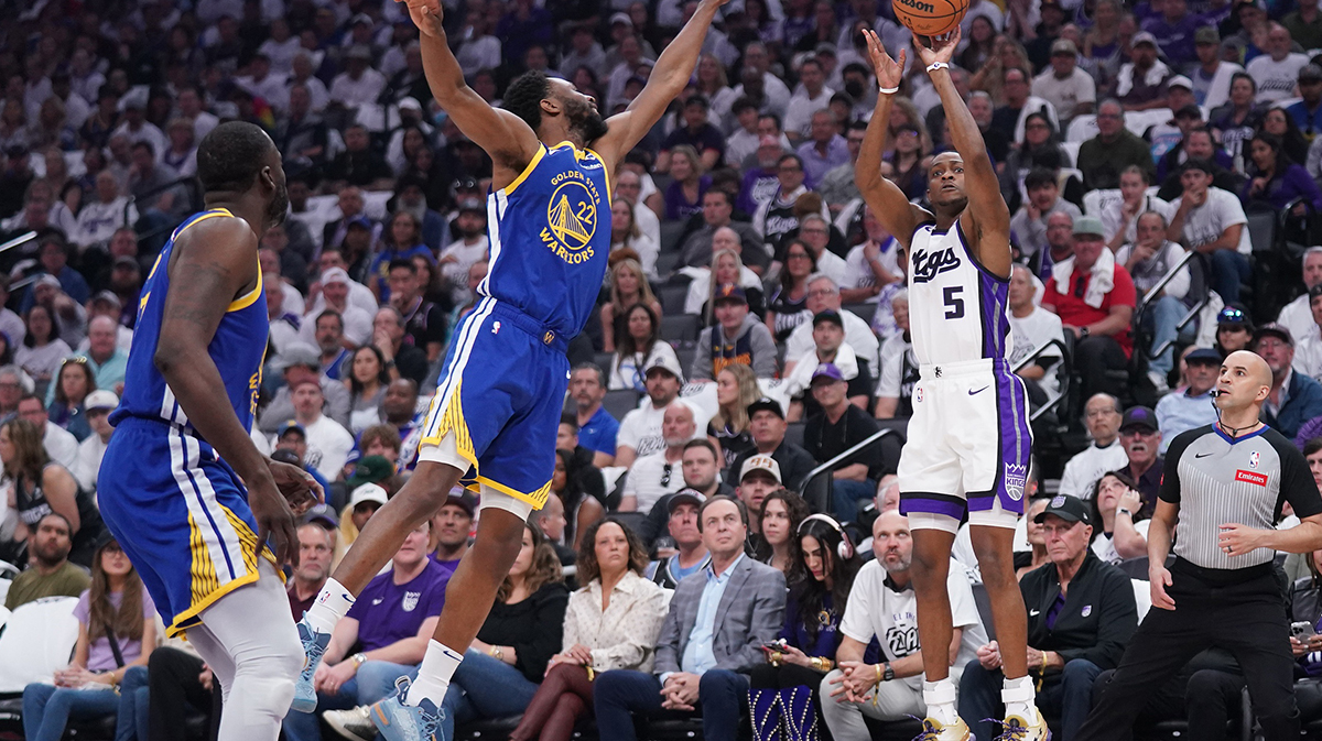 Sacramento Kings guard De'Aaron Fox (5) shoots over Golden State Warriors forward Andrew Wiggins (22) in the first quarter during a play-in game of the 2024 NBA playoffs at the Golden 1 Center.