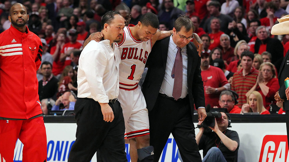 Chicago Bulls injured point guard Derrick Rose (1) is helped off the court by medical staff during the fourth quarter in the Eastern Conference quarterfinals of the 2012 NBA Playoffs against the Philadelphia 76ers at the United Center. The Bulls won 103-91.