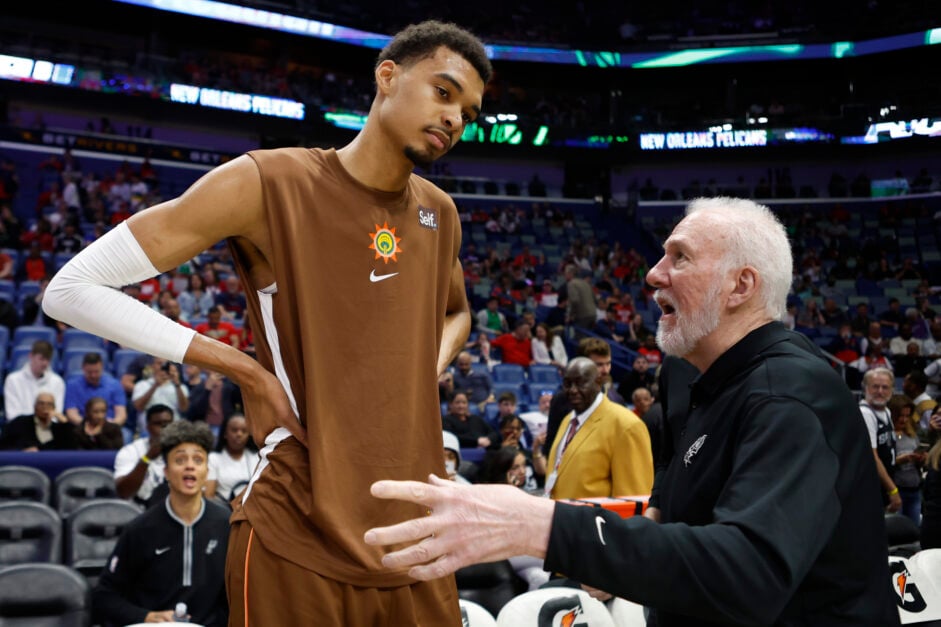 San Antonio Spurs center Victor Wembanyama confers with head coach Gregg Popovich