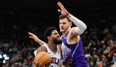 Paul George #8 of the Philadelphia 76ers drives into Walker Kessler #24 of the Utah Jazz