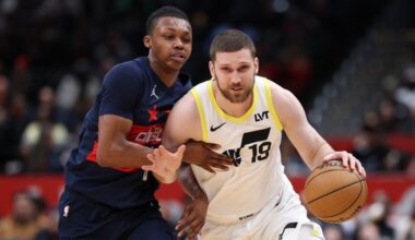 Svi Mykhailiuk #19 of the Utah Jazz handles the ball in front of Bub Carrington #8 of the Washingto...