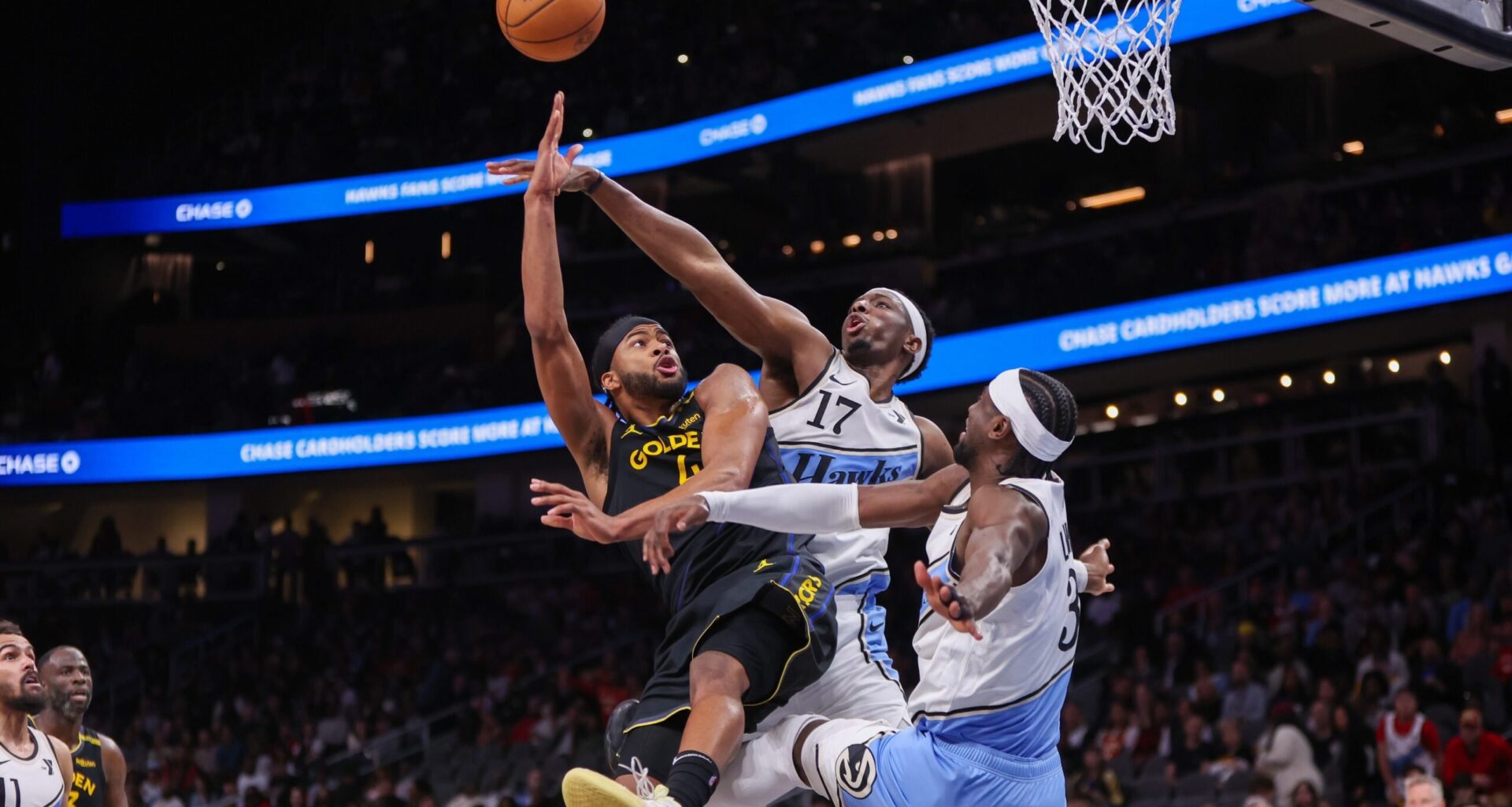 Golden State Warriors guard Moses Moody (4) shoots past Atlanta Hawks forward Onyeka Okongwu (17) and guard Caris LeVert (3)