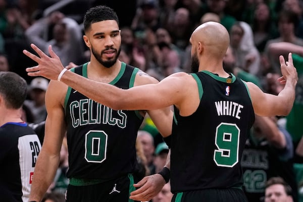 Boston Celtics forward Jayson Tatum (0) celebrates with teammate Derrick White while leading the Orlando Magic during the second half in Game 5 of a first-round NBA playoff basketball series, Tuesday, April 29, 2025, in Boston. (AP Photo/Charles Krupa)