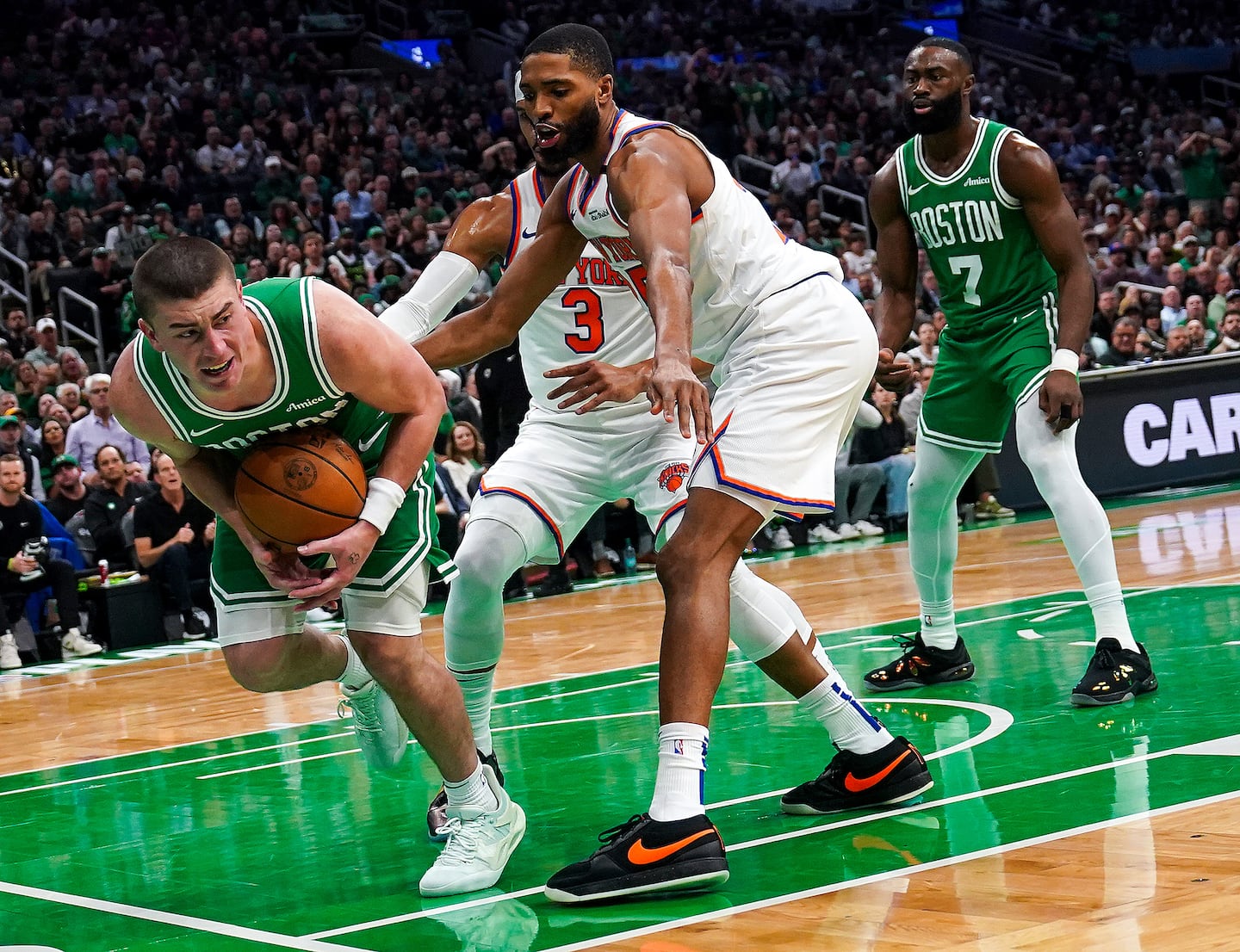 Boston Celtics guard Payton Pritchard (11) grasps after a loose ball to try and keep it inbounds during the first quarter.
