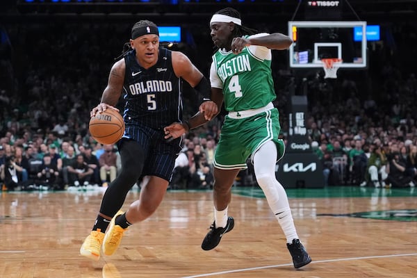 Orlando Magic forward Paolo Banchero (5) drives to the basket against Boston Celtics guard Jrue Holiday (4) during the first half in game 2 of a first-round NBA playoff basketball series, Wednesday, April 23, 2025, in Boston. (AP Photo/Charles Krupa)