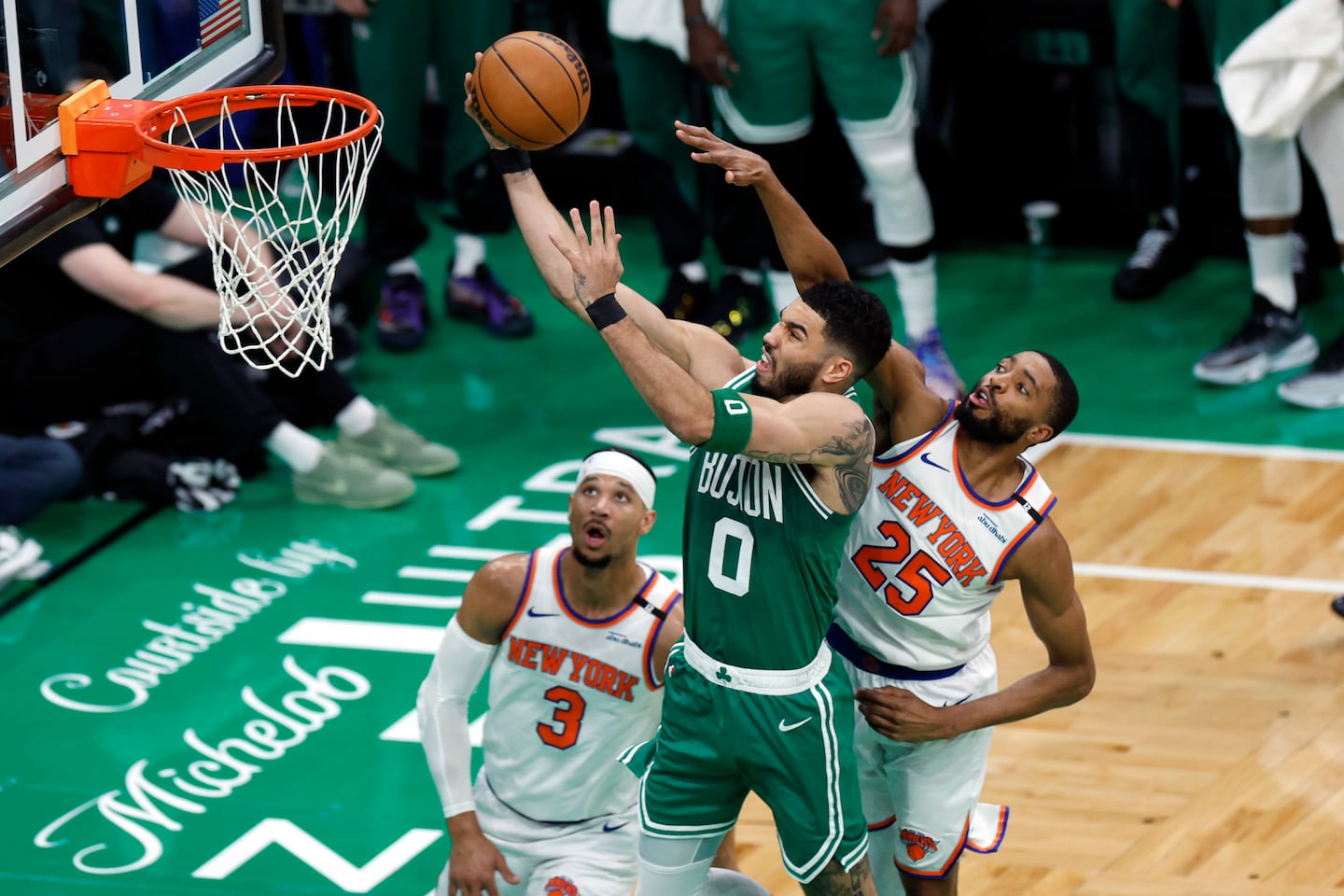 Boston Celtics forward Jayson Tatum (0) drives to the basket through New York Knicks forward Mikal Bridges (25) and guard Josh Hart (3) during the first quarter.