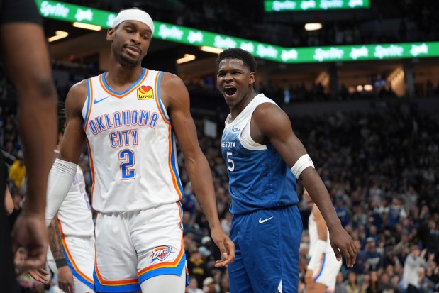 Minnesota Timberwolves guard Anthony Edwards (5) celebrates next to Oklahoma City Thunder guard Shai Gilgeous-Alexander (2) after making a basket and being fouled during the first half of an NBA basketball game Saturday, Jan. 20, 2024, in Minneapolis. (AP Photo/Abbie Parr)