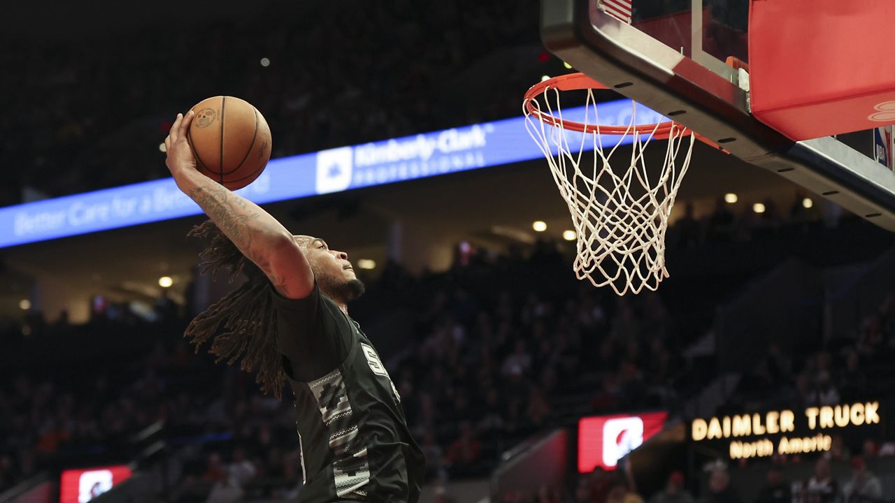 San Antonio Spurs guard Stephon Castle (5) dunks against the Portland Trail Blazers during the second half of an NBA basketball game Sunday, April 6, 2025, in Portland, Ore. (AP Photo/Amanda Loman)