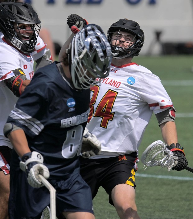 Maryland Terrapins midfielder George Stamos, left smiles as Geordy Holmes...