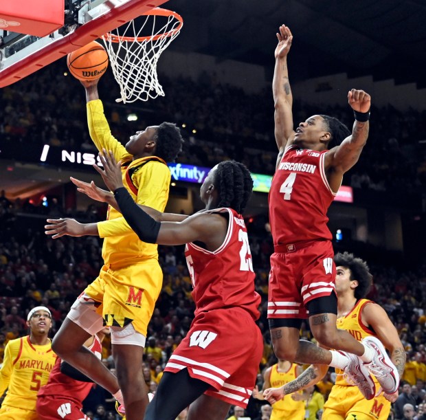 Maryland's Derik Queen, left, scores against Wisconsin's Kamari McGee, from right, and John Blackwell in the second half. Maryland defeated Wisconsin 76-68 in men's basketball game at Xfinity Center. (Kenneth K. Lam/Staff)